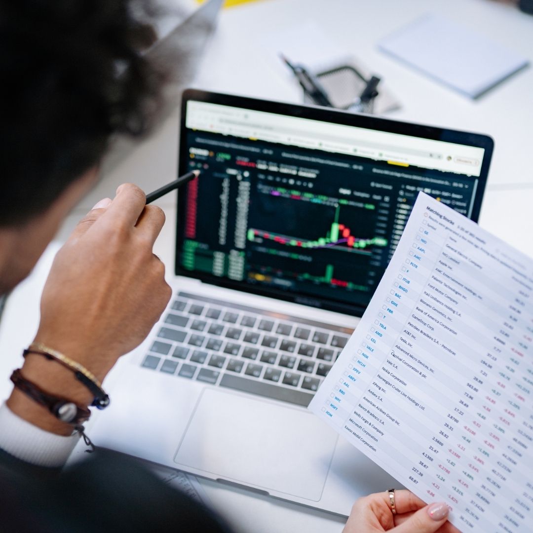 Investor reviewing a UK share portfolio and financial documents while preparing to relocate overseas.